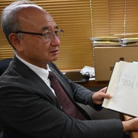 製本された社務日誌を開く土肥原弘久さん＝長崎市上西山町で