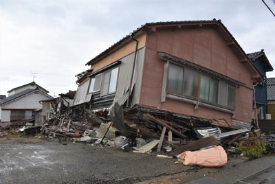 1階部分が自動車ごと押し潰されたままの民家。市街地のあちこちに倒壊した家が残っている＝石川県輪島市で2024年12月1日午後1時14分、国本ようこ撮影