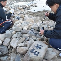 積み直した石に願いを書く参加者＝兵庫県宝塚市で2024年12月7日午前10時38分、土居和弘撮影