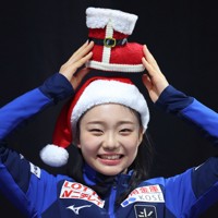 ジュニア女子フリーから一夜明け、クリスマスグッズを手に写真撮影に応じる和田薫子＝フランス・グルノーブルで2024年12月7日、猪飼健史撮影