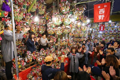 縁起物の熊手が売れるたびに威勢のいいかけ声とともに祝いの手締めが響き渡った酉の市＝東京都台東区の鷲神社で2014年11月10日、長谷川直亮撮影