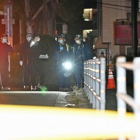 中学生2人が刺されたマクドナルド322徳力店の周辺を調べる捜査員ら＝北九州市小倉南区で2024年12月15日午前0時11分、平川義之撮影