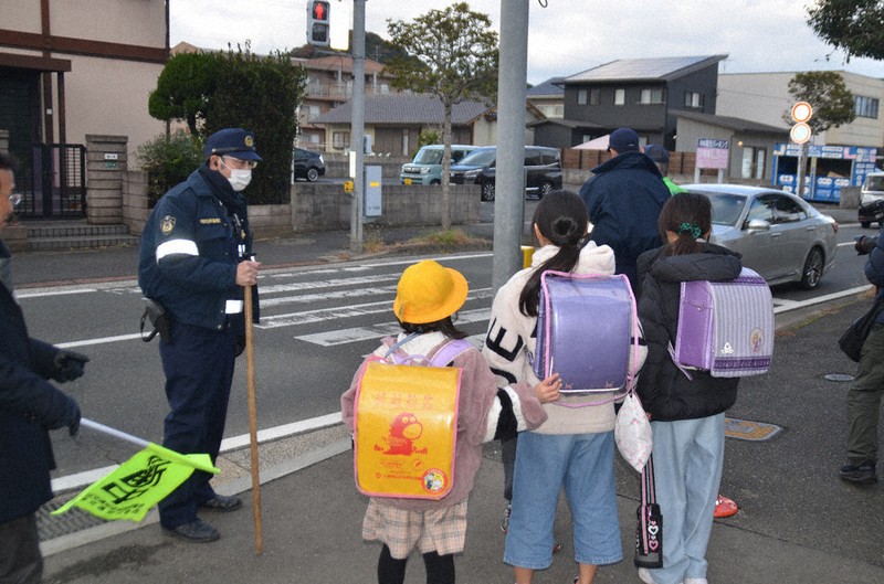 警察官や教諭に見守られ下校する児童＝北九州市小倉南区で16日、山下智恵撮影