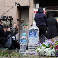 大阪・北新地の放火殺人事件から3年となった朝、現場のビルの前には花束と水が供えられていた＝大阪市北区で2024年12月17日午前8時18分、岩本一希撮影