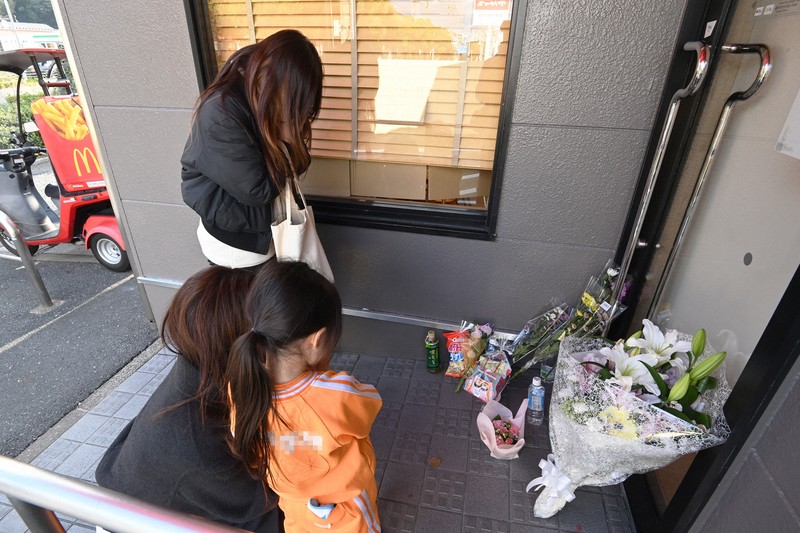 事件現場のファストフード店入り口には、この日も花束やお菓子を供え、手を合わせる人が相次いだ＝北九州市小倉南区で2024年12月17日午後2時57分、上入来尚撮影（画像の一部を加工しています）