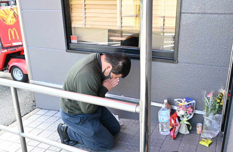 事件で亡くなった女子中学生をしのび、供え物をして手を合わせる男性＝北九州市小倉南区で2024年12月19日午後0時13分、平川義之撮影