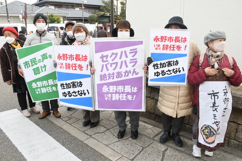 大阪府岸和田市の永野耕平市長の辞職を求め、市役所前でプラカードを掲げる市民ら＝岸和田市で2024年12月20日午前9時7分、中村宰和撮影