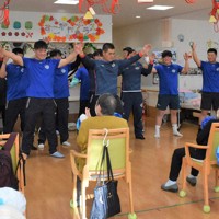 お年寄りの手拍子に合わせて「ヤングマン」を踊る朝明の選手たち＝三重県四日市市生桑町で2024年12月19日、下村恵美撮影