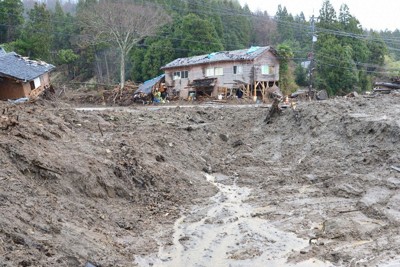 豪雨で流出した土砂や流木に埋まったままになっている民家＝石川県輪島市町野町で2024年12月21日午後2時50分、阿部弘賢撮影