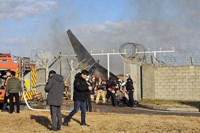 墜落現場に駆けつけた消防隊員ら＝韓国南西部の務安国際空港で2024年12月29日、ニューシス・AP