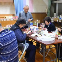 避難所で刺し身やカップ麺などを食べながら大みそかの夜を過ごす能登豪雨の被災者＝石川県珠洲市で2024年12月31日午後5時26分、阿部弘賢撮影