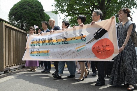 A group of plaintiffs head to the Tokyo District Court holding a banner in their hands, which reads "Toward a society where married couples can choose separate surnames!" in Tokyo's Chiyoda Ward on June 27, 2024. (Mainichi/Ran Kanno) 