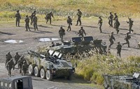 Japan Ground Self-Defense Force and U.S. Marine Corps personnel get out of an armored vehicle during the "Resolute Dragon" joint drill on Oct. 29, 2023, at Hijudai artillery range in Oita Prefecture, southwestern Japan. (Kyodo)