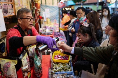 春節向けの商品を買う人でにぎわう市場＝台北市で13日、ロイター