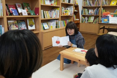 表情豊かに、語りかけるように絵本を読み聞かせる松永朝恵さん（中央）＝福井県敦賀市の絵本カフェ「ハチドリ」で、高橋隆輔撮影