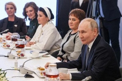 家族がウクライナ侵攻に参加した女性らと話すロシアのプーチン大統領（手前）＝6日、モスクワ（ロシア大統領府提供・タス＝共同）