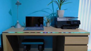 Twinkly Line smart lights on edge of desk, illuminated with blue and green wave pattern