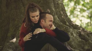 Lana consoles a crying Cliff by a tree in Black Mirror season 6