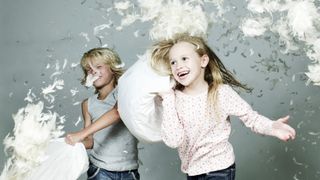 Children having a pillow fight with feathers flying everywhere