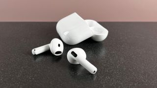 AirPods 4 next to their open case on a table