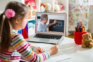 Young girl learning remotely on a laptop