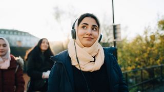 Asian woman listing to music as she walks