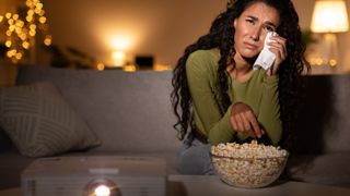 Femme en pleurs regardant un film triste sur un vidéoprojecteur