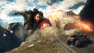 Just Cause 4 screenshot of protagonist Rico Rodriguez parachuting down as an explosion happens near a truck in the background