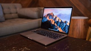 Una MacBook Pro en una mesa de café al lado de un sofá