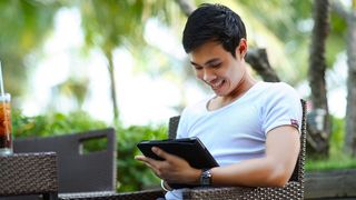 A person using a tablet outdoors.