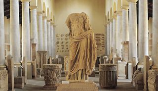 A photograph of a headless statue in a museum