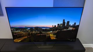 Philips OLED809 with blue ambilight and city at dusk on screen