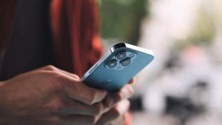 A person holding a blue iPhone 13 in both hands