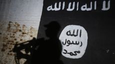 An Iraqi soldiers walks past a Islamic State logo inside a tunnel formerly used as a training facility by jihadist fighters near Mosul, in 2017 