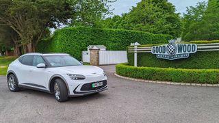 A white EV parked outside the Goodwood race circuit