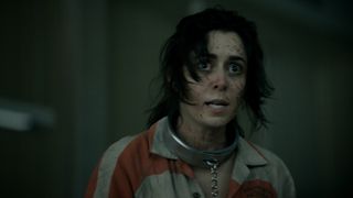 A frenzied and bloodied Sofia Falcone wearing a prison suit and chains in The Penguin