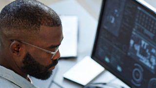 Man working at his desk with a monitor