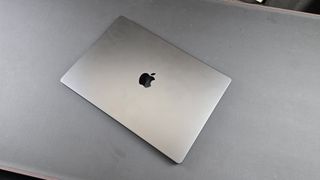 En 16-tommers MacBook Pro med en M4 Pro-brikke ligger lukket på et bord.