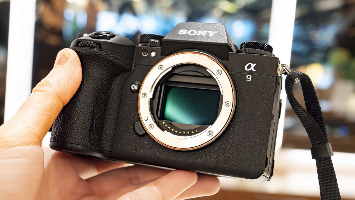 Sony A9 III in the hand without lens and light reflecting off the camera&#039;s sensor