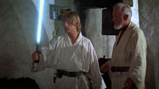 A still from star wars in which luke is holding a lightsaber and obi wan is stood behind him