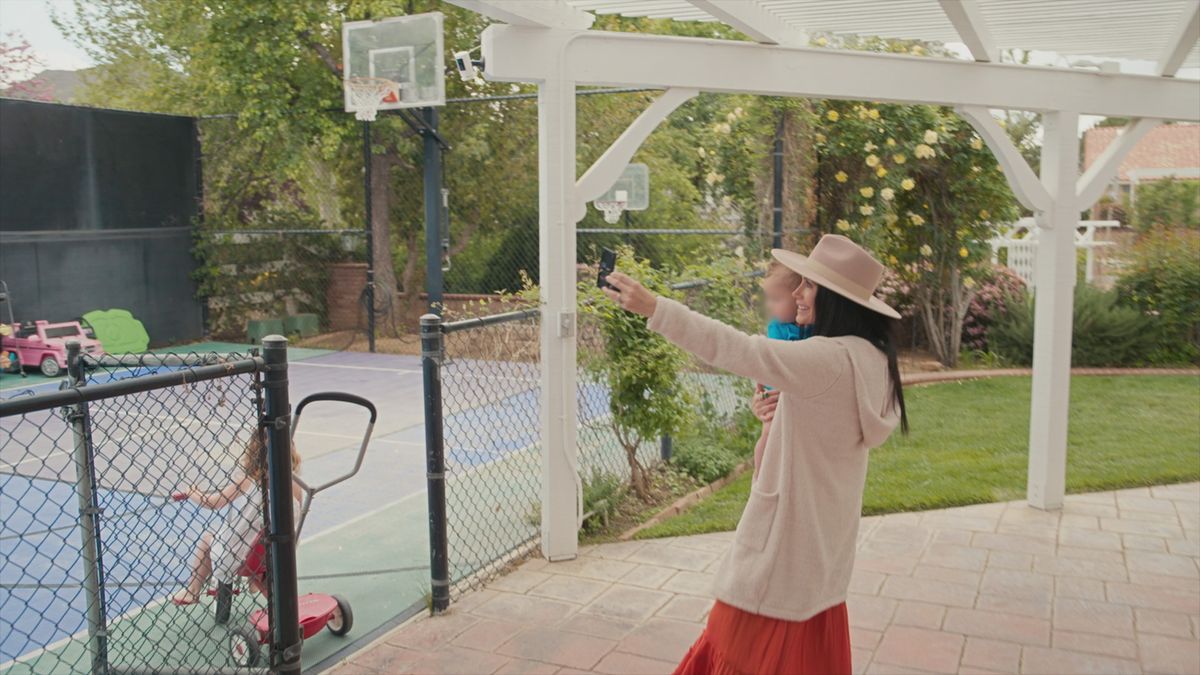 Vlogger Channon Rose filming herself playing with her children by a basketball court in An Update on Our Family