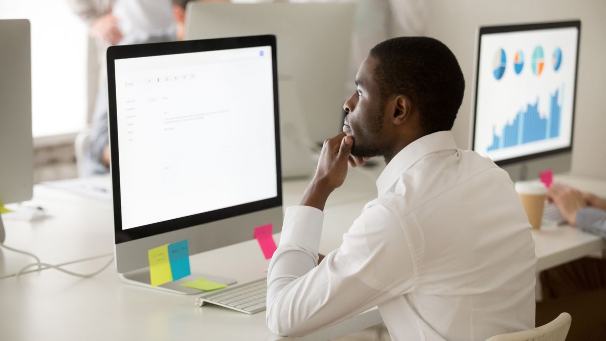 A man working at an office and looking at his screen while using Gmail