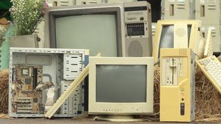 Old low tech broken computer parts in a pile next to straw