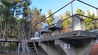 The now-unused bases of telescopes sit on a concrete platform.