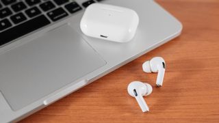 Air Pods Pro. macbook. avec étui de chargement sans fil. Nouveau Airpods pro sur fond de bois. Airpods.