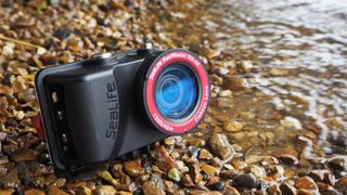 SeaLife ReefMaster RM-4K waterproof camera on a stony waterside