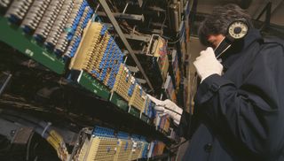 A technician uses telephonic tapping equipment. 