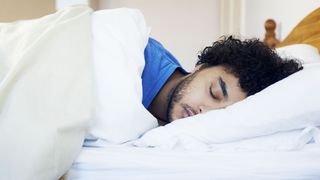 Man asleep on his side in bed