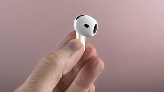 AirPods 4 bud held in a hand, showing the speaker section