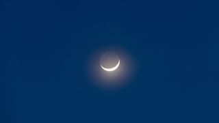 Earthshine on moon in a dark blue sky